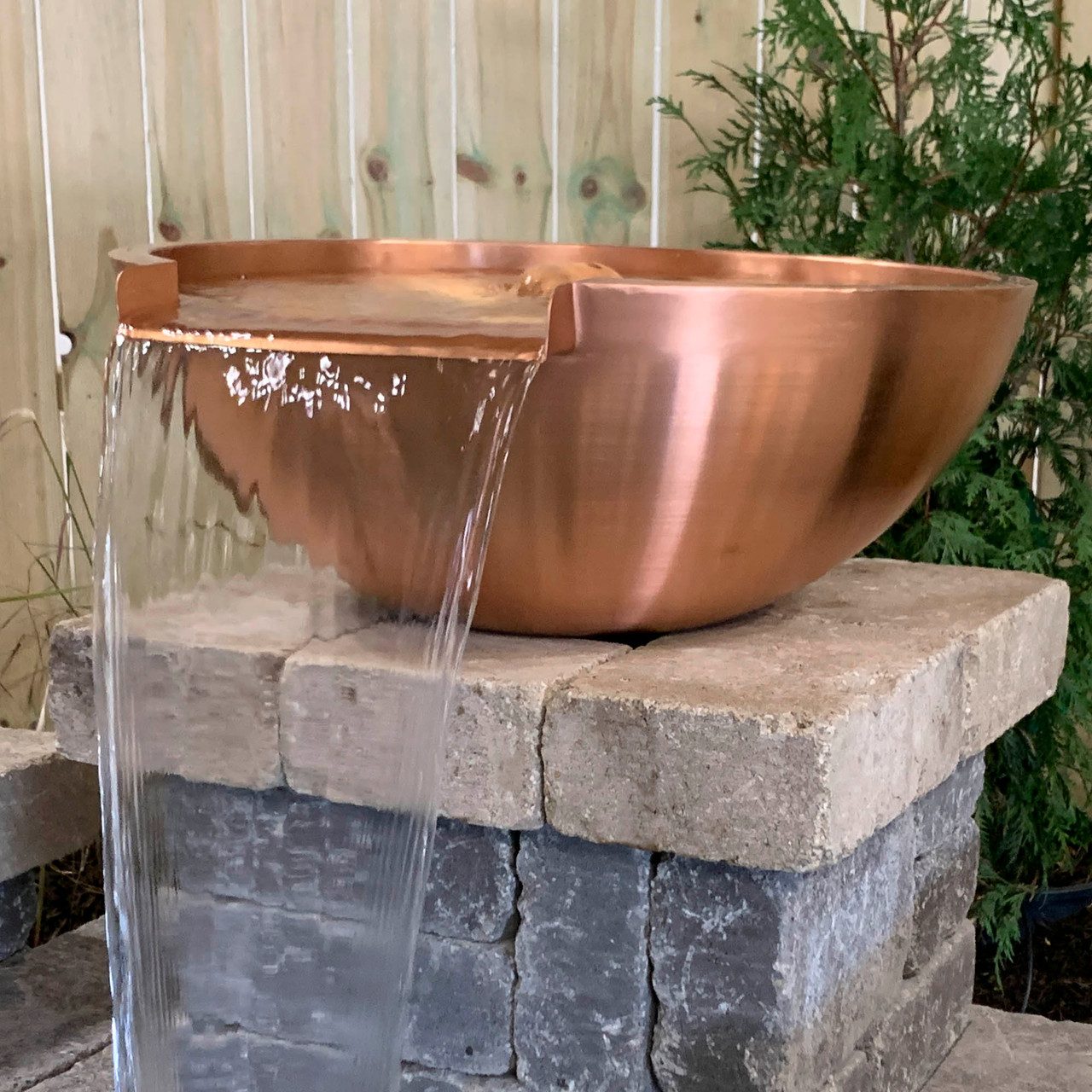 Copper spillway bowl on a stone pillar, built by iPond and Landscapes