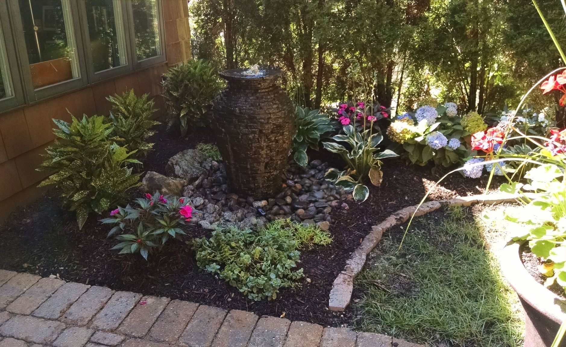 Urn fountain in a planted bed, built by iPond and Landscapes