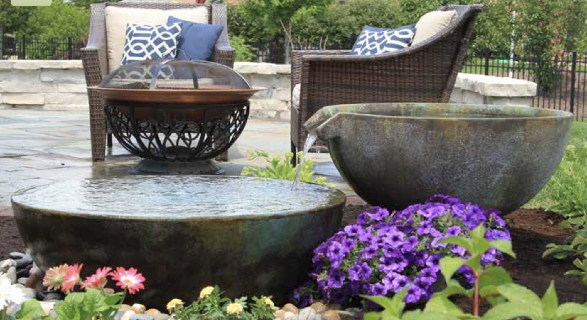 Spillway bowls beside a patio fire pit, built by iPond and Landscapes